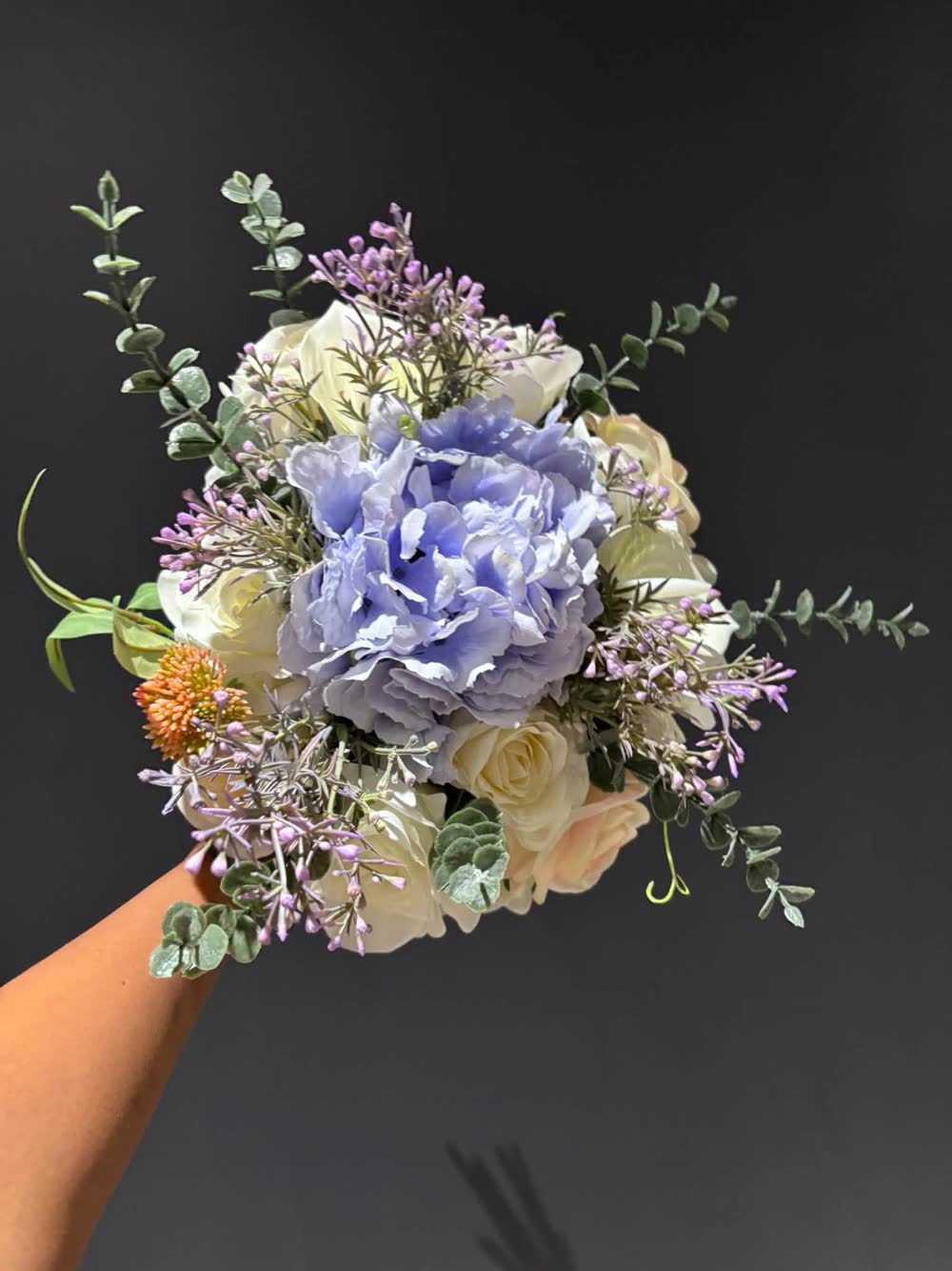 Hand-held bouquet with a lilac hydrangea, cream roses and eucalyptus